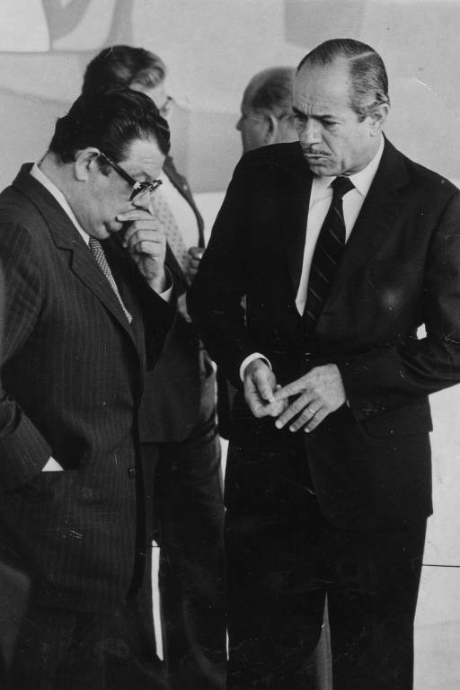 Os ministros Delfim Netto e Ernane Galvêas, ambos acusados no "Escândalo Coroa-Brastel", conversam durante discurso do presidente João Figueiredo, em Brasília, em 1983