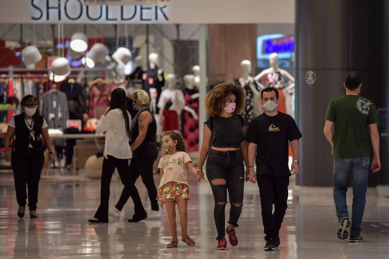 Casal com criança anda em shopping em São Paulo