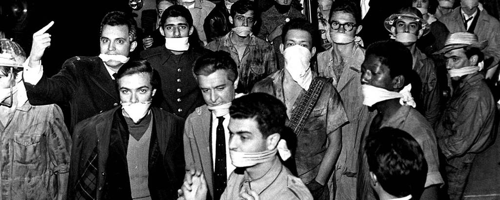 Na imagem em preto e branco, pessoas aparecem com panos amarrados na boca.