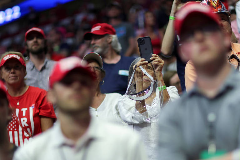 Apoiadora de Donald Trump segura proteção facial durante comício republicano em Tulsa