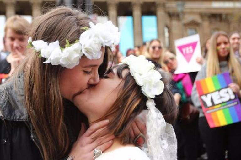 Duas mulheres se beijam em uma parada do orgulho LGBT