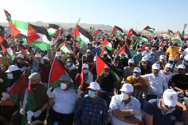 Palestinos usando máscaras participam de uma manifestação em Jericó organizada pelo presidente da Autoridade Palestina, Mahmoud Abbas, para protestar contra os planos de Israel de anexar partes da Cisjordânia.