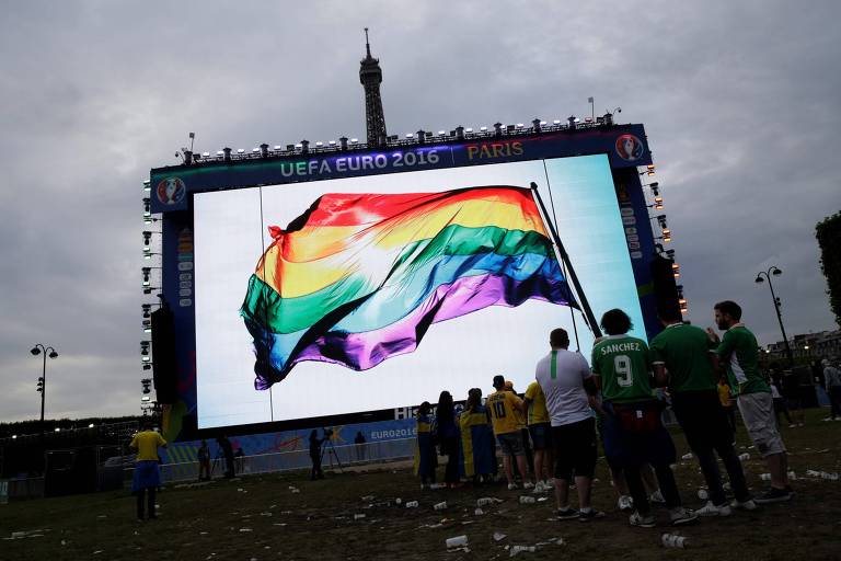 Bandeira com as cores do arco-íris no telão de uma 'fan zone' da Eurocopa de 2016, em Paris
