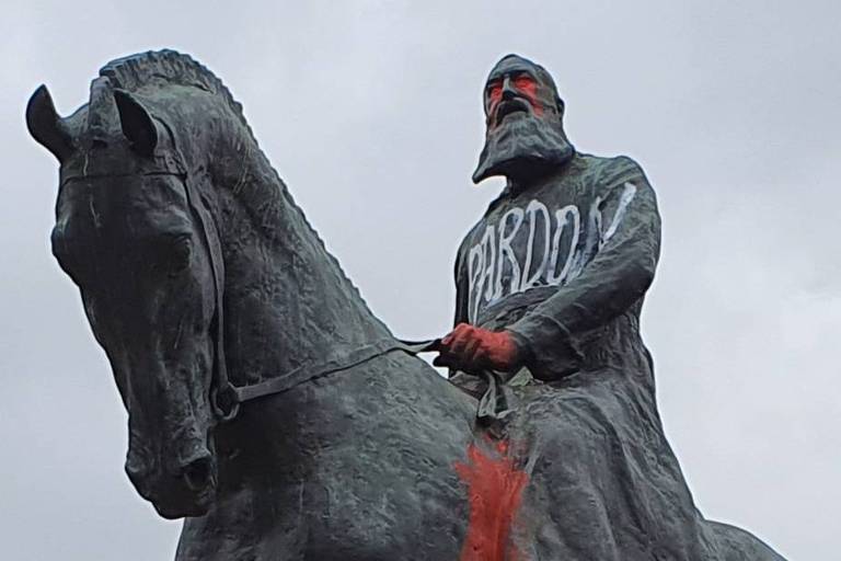 Estátua de homem de casaca e barbas longas sobre cavalo, com os olhos pintados de vermelho como se chorasse sangue e a palavra perdão escrida no peito