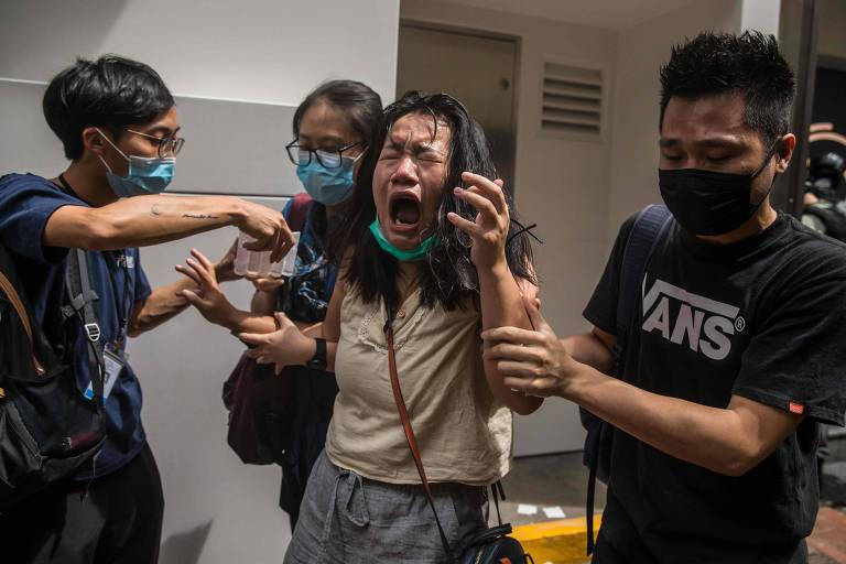 Mulher reage depois de ser atingida por spray de pimenta durante protesto em Hong Kong