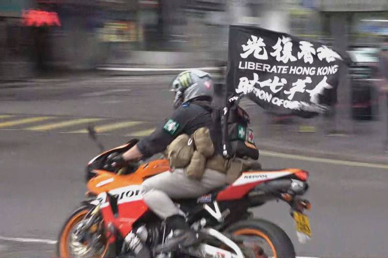 Motociclista carrega bandeira com slogan separatista em Hong Kong