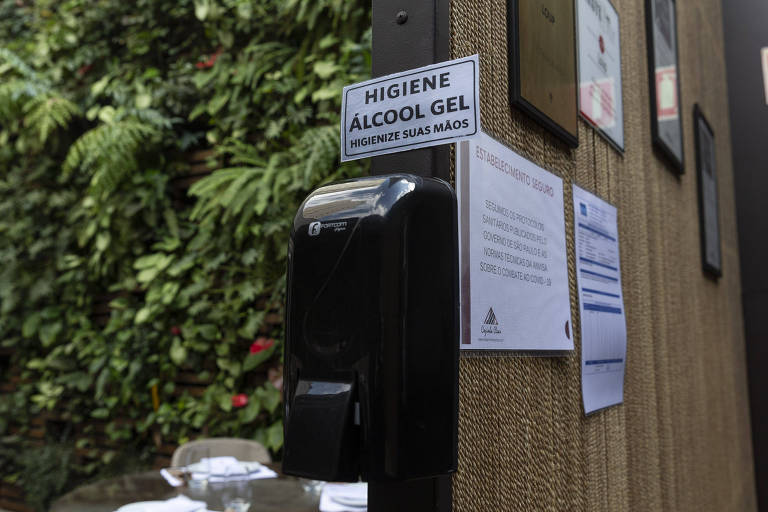 Distribuidor de álcool gel na entrada do restaurante.
