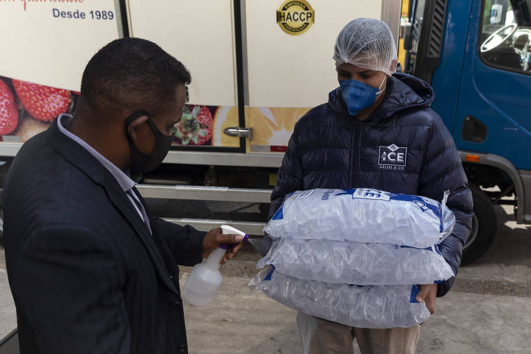Funcionário do restaurante Loup borrifa álcool nos sacos de gelo que chegam ao restaurante. 