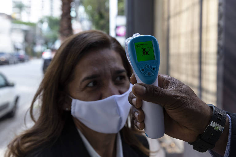 Funcionária do Loup tem sua temperatura medida na entrada do restaurante. 