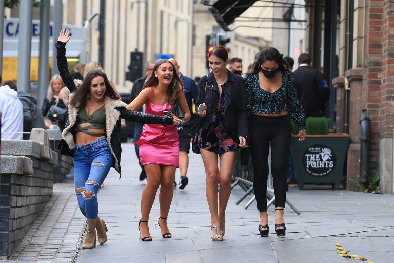 Quatro amigas caminham juntas no fim da tarde de sábado em Newscastle, no norte da Inglaterra, para comemorar a reabertura dos pubs