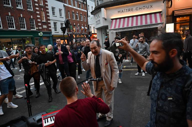 Homem repreende músico que tocava para frequentadores de pubs no Soho, em Londres