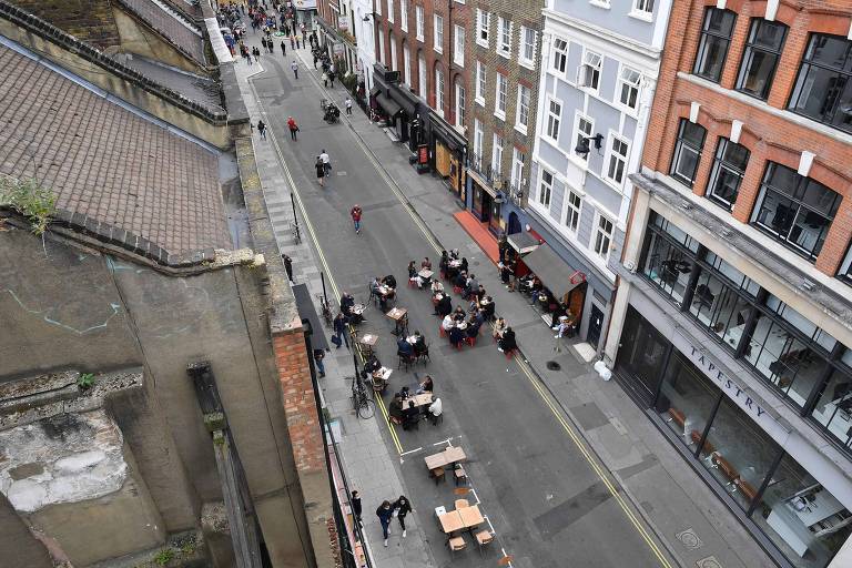 Bares e restaurantes ocupam via fechada para o trânsito na região do Soho, em Londres; o bairro tornou vias exclusivas para pedestres
