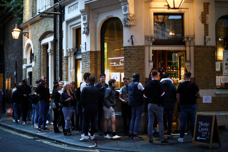 Pessoas fazem fila em bar do Borough Market, em Londres, reaberto neste sábado