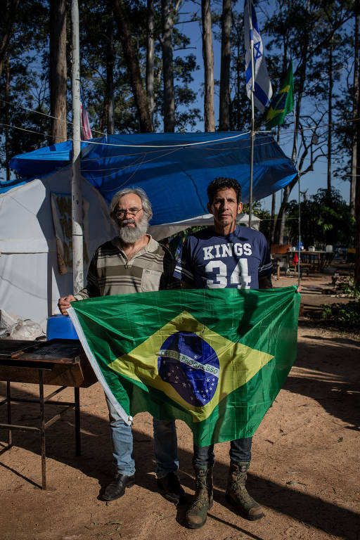 O ex-militar Jurandir Pereira Alencar, 58, e o engenheiro Antonio Carlos Bronzeri, 64, (de barba) em acampamento bolsonarista onde agora cumprem prisão domiciliar
