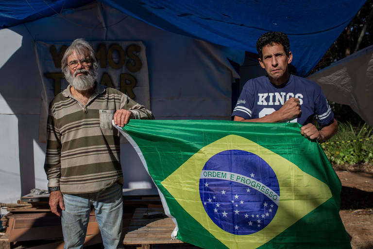O ex-militar Jurandir Pereira Alencar, 58, e o engenheiro Antonio Carlos Bronzeri, 64, (de barba) em acampamento bolsonarista onde agora cumprem prisão domiciliar