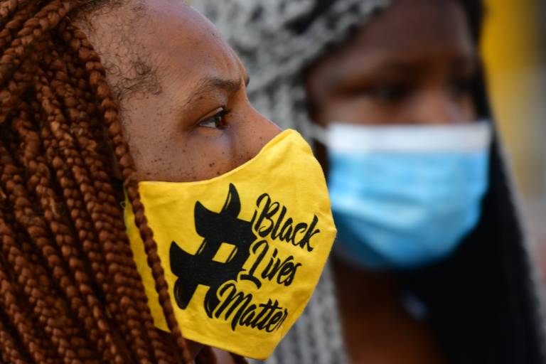 Mulher negra usa máscara estilizada com a inscrição 'Black Lives Matter' (vidas negras importam), em Nova Jersey