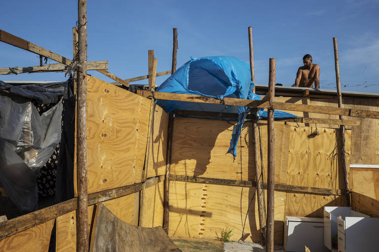 Morador trabalha na construção de barraco na ocupação