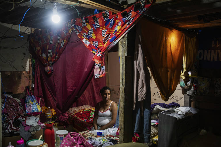 Juliana Claudia de Lima, 26, desempregada, dentro de seu barraco