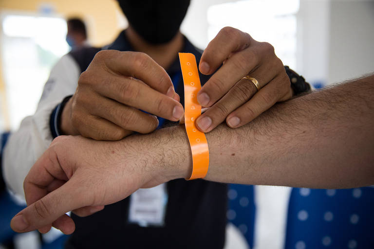 Fita laranja é colocada em braço de passageiro no aeroporto de Carauari, no Amazonas