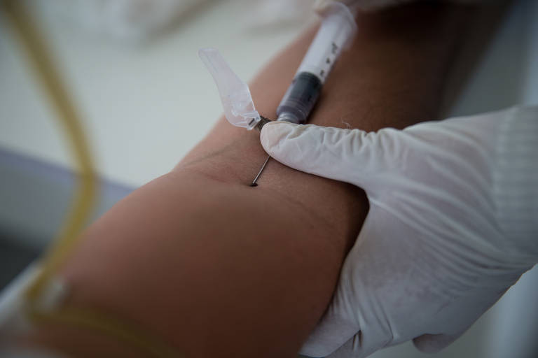 Técnica de enfermagem tira sangue de passageiro para exame de Covi-19 em Carauari, no Amazonas