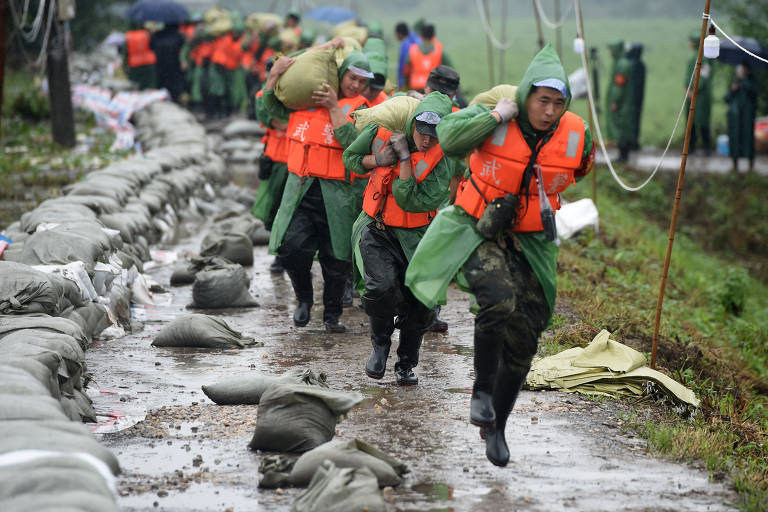 Policiais reforçam dique na China; veja fotos de hoje