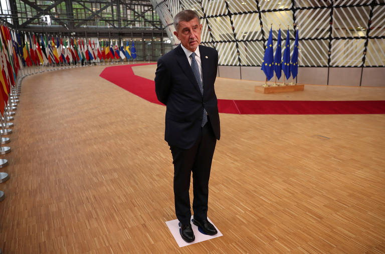 O primeiro-ministro da República Tcheca, Andrej Babis, se posiciona sobre um marcador de distanciamento, durante pronunciamento