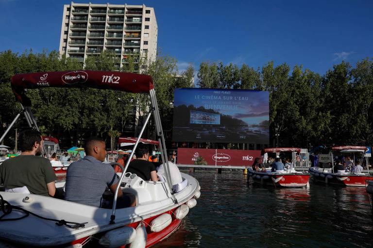 De dentro de barcos, pessoas assistem ao filme francês "Le grand bain", no 1º dia da 19ª edição do "Paris-Plages", na capital francesa