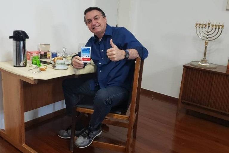 O presidente Jair Bolsonaro exibe caixa de cloroquina ao anunciar em redes sociais que exame para Covid-19 deu negativo