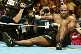 Mike Tyson sits on the canvas after being knocked out by Danny Williams