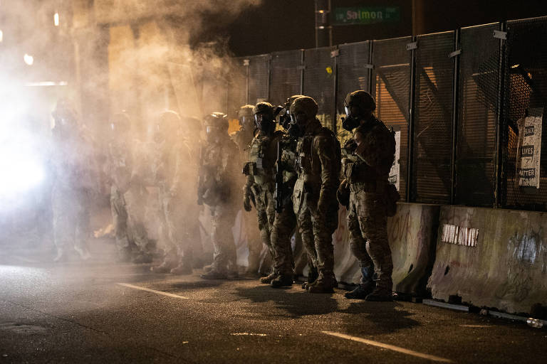 Agentes de forças federais guardam o fórum Mark O. Hatfield após atirarem gás lacrimogêneo em manifestantes durante um protesto antirracismo em Portland, no estado de Oregon