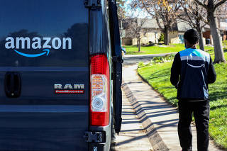 FILE PHOTO: An Amazon worker delivers packages