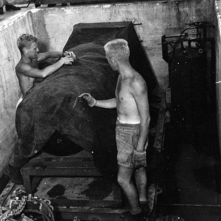 Dois cadetes removem a cobertura de lona da bomba atômica, Little Boy, em agosto de 1945