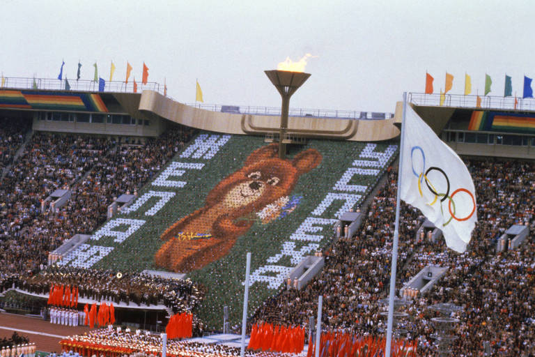O público no estádio Olímpico de Moscou mostra mosaico do urso Misha, mascote dos Jogos de 1980, durante a cerimônia de abertura