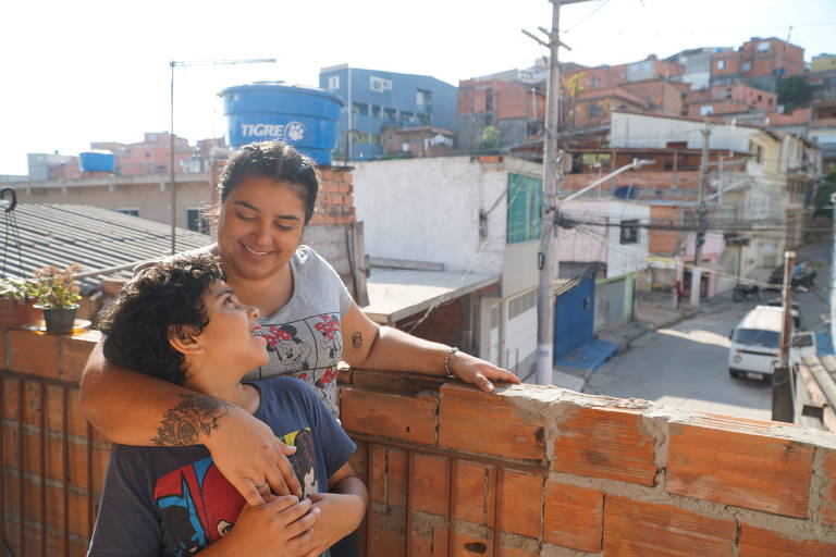 Karina, 29, e o filho Rodrigo, 9, na varanda de casa na Vila Menk, em Carapicuíba, na Grande São Paulo. Para a manicure, o filho não voltaria para escola antes de uma vacina