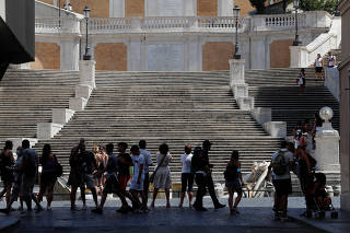 People walk along Piazza di Spagna square in Rome