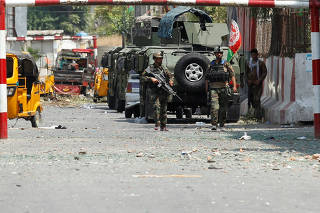 Afghan security forces keep watch in front of the site of an attack on a jail compound in Jalalabad