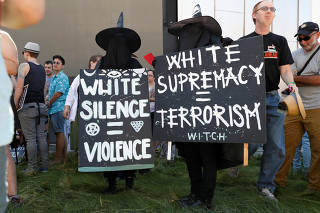 Demonstrators hold signs during the Bay Area Rally Against Hate counter-protest against the cancelled No Marxism in America rally in Berkeley