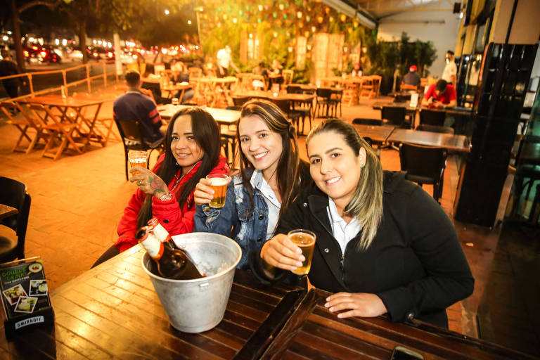 Bar com movimento fraco na noite de quinta-feira (6), na avenida Luís Dumont Villares, na Vila Guilherme (zona norte da capital), quando foi liberada a reabertura até as 22h na cidade; meses estavam com distanciamento; as amigas Sara Andrade, Amanda Borges e Lisley Carolino aproveitaram a reabertura