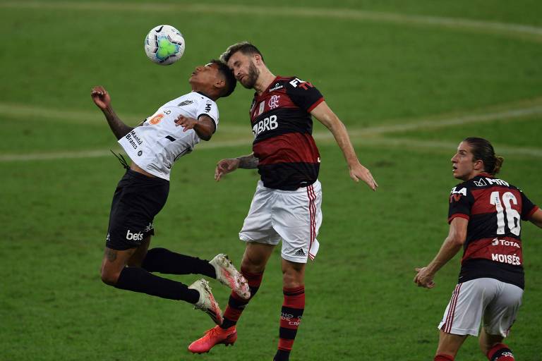 Marrony (de branco), do Atlético-MG, e Léo Pereira, do Flamengo, disputam bola durante partida entre as duas equipes na primeira rodada do Brasileiro 