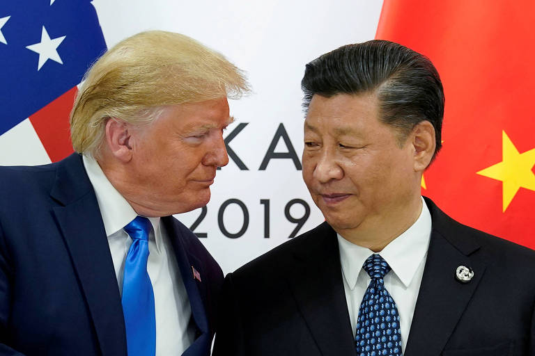 Trump conversa com Xi Jinping com as bandeiras dos dois países ao fundo.