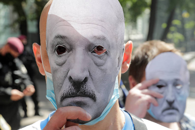 Manifestante usa máscara de papel com o rosto do presidente da Belarus, Aleksandr Lukachenko