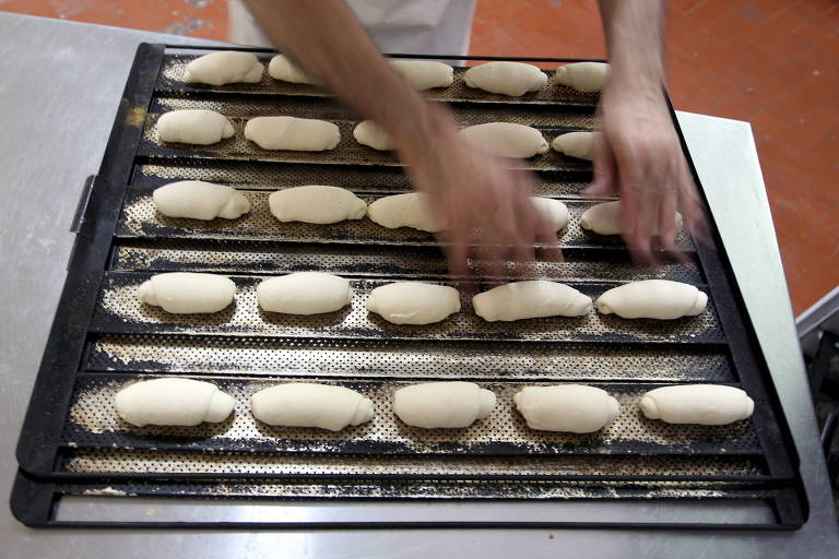Trabalhador prepara pão em padaria de São Paulo