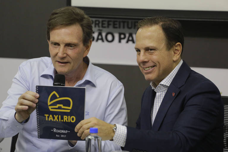 O então prefeito de São Paulo, João Doria (PSDB), acompanhado do prefeito do Rio, Marcelo Crivella (PRB), anuncia o lançamento do aplicativo SPTáxi