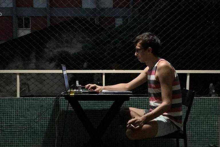 Ator sentado em sua varanda encena peça pelo computador