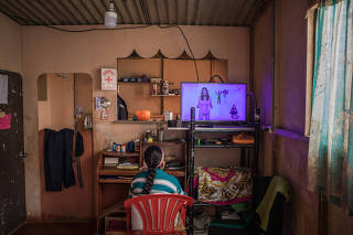 Delia Huamani, 10, watches a broadcasting of remote school lessons at her home in Pedregal, Peru, Aug. 13, 2020. (Marco Garro/The New York Times)