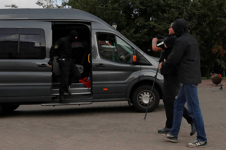 Agentes de segurança detêm jornalista que cobria protestos em Minsk, na Belarus; o autor da foto também foi levado em seguida