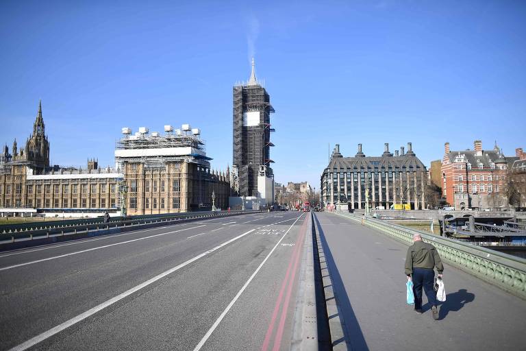 Homem caminha em rua vazia em frente ao parlamento