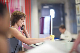 Young businesswoman using telephone in office