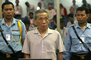 FILE PHOTO: Former Khmer Rouge S-21 prison chief Duch stands in a courtroom during a pre-trial in Phnom Penh