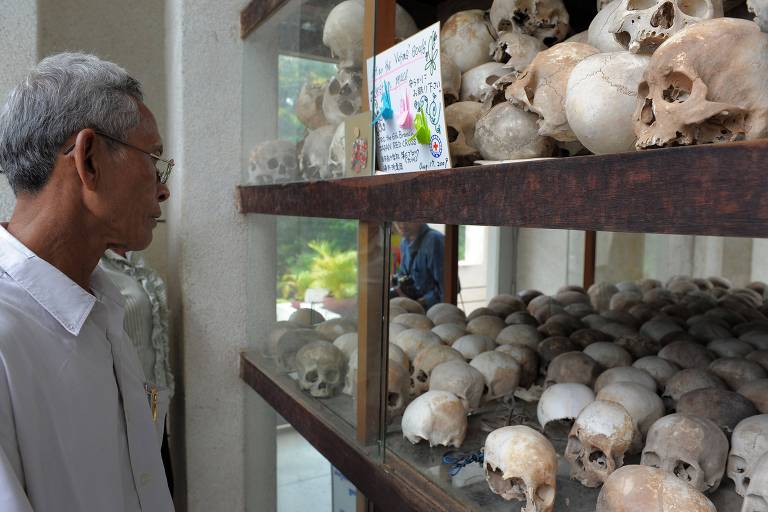 Visitante observa crânios de vítimas do Khmer Vermelho em Tuol Sleng, prisão que foi comandado por Duch e onde hoje funciona um museu sobre o genocídio cambojano